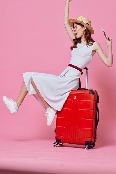 Young woman with red suitcase in studio - Foto, afbeelding