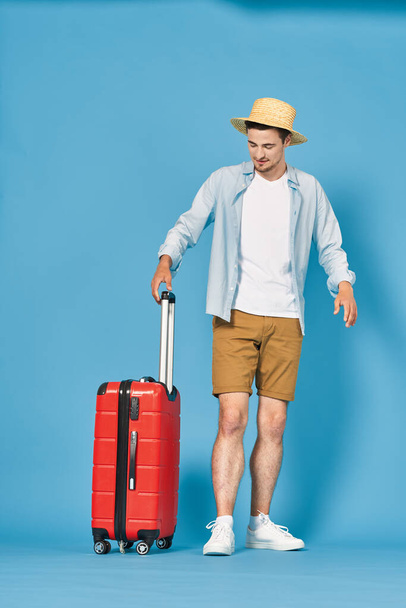 Young man with red suitcase in studio - Photo, image