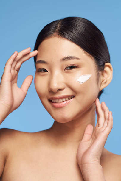 Fiatal ázsiai nő alkalmazása hidratáló az arcán  - Fotó, kép