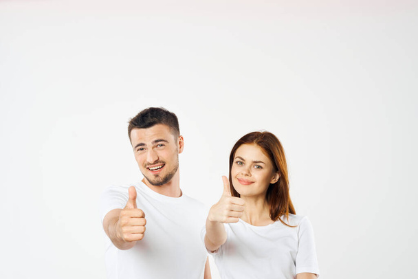 Young  couple  in studio with thumbs up  on isolated background - Фото, изображение