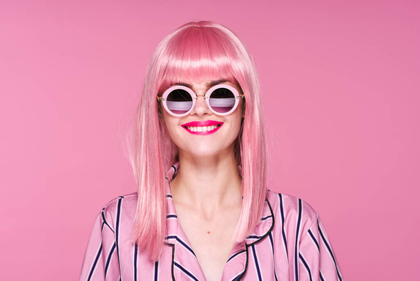 giovane bella donna in parrucca rosa e occhiali da sole in posa in studio
  - Foto, immagini