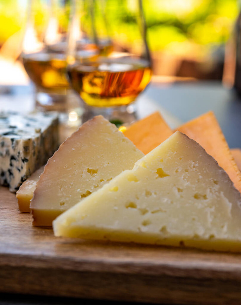 Emparelhamento de uísque e queijo, degustação de copos de uísque e prato com queijos fatiados de perto
 - Foto, Imagem