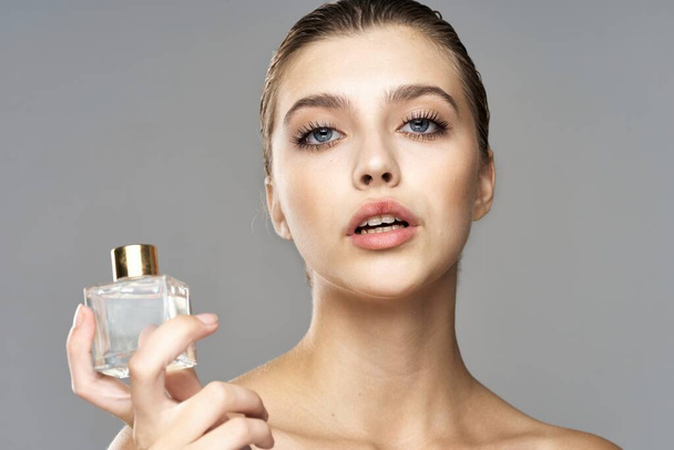 portrait of young beautiful woman with perfume bottle.  Studio shot.   - Photo, image