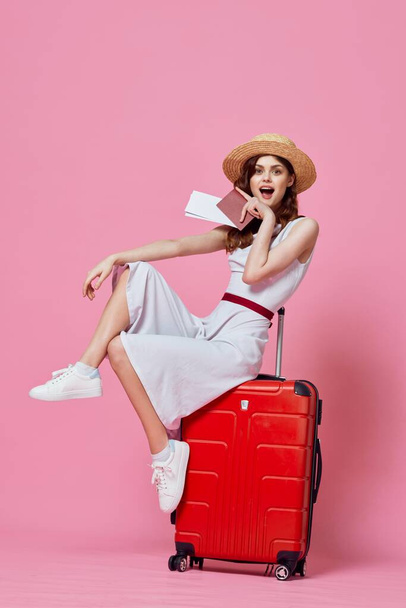 Young woman with red suitcase in studio - Фото, изображение
