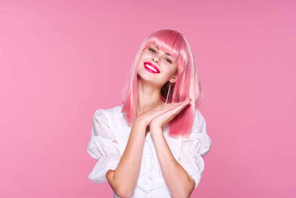 молодая красивая женщина в розовом парике позирует в студии
  - Фото, изображение