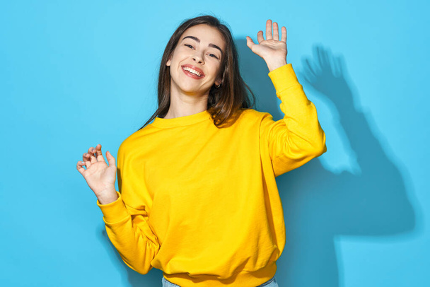 Young beautiful woman   dancing  in studio isolated on blue background  - Photo, Image