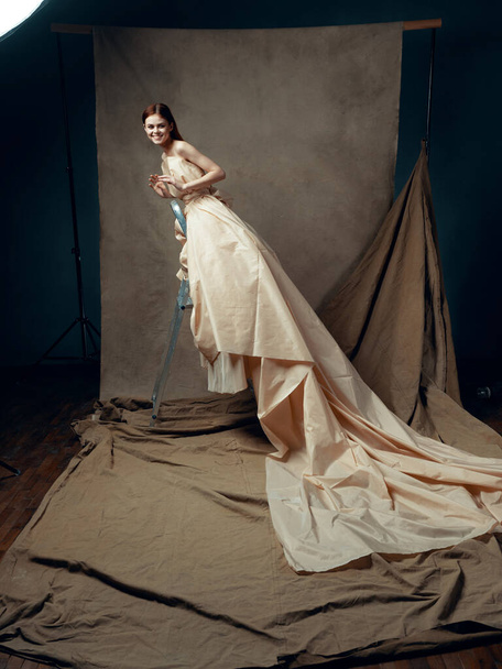 Young beautiful woman in gown posing in studio - Fotografie, Obrázek