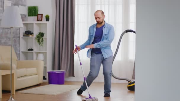 Divertente uomo pulizia appartamento - Filmati, video