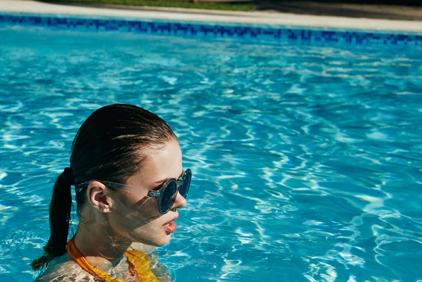 νεαρή όμορφη γυναίκα χαλαρώνει στην πισίνα   - Φωτογραφία, εικόνα