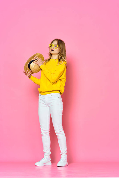 young beautiful woman holding straw hat   in studio on pink background       - Foto, Imagen