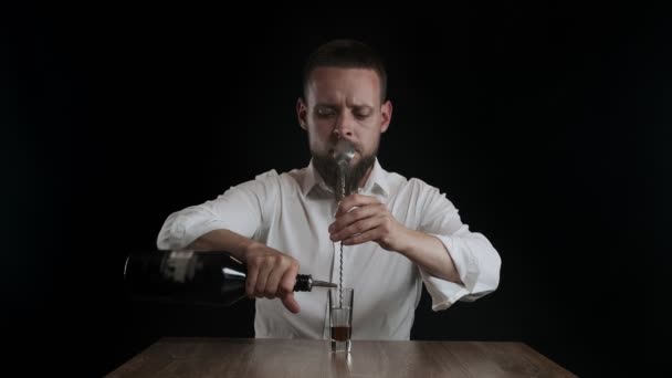 The bartender pours irish cream from a bottle to cocktail glass - Footage, Video