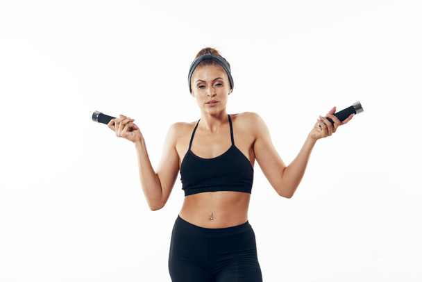 Athletic woman exercising with dumbbells. Studio shot  - Photo, Image