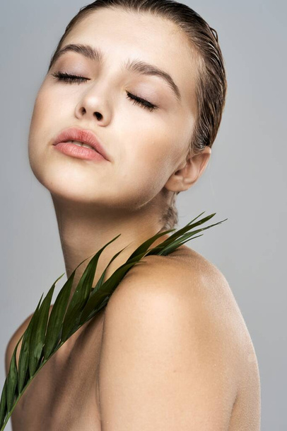 Young beautiful woman posing  with  leaf in studio - Photo, Image