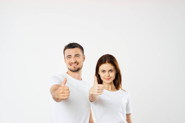 Young  couple  in studio with thumbs up  on isolated background - Foto, Imagen
