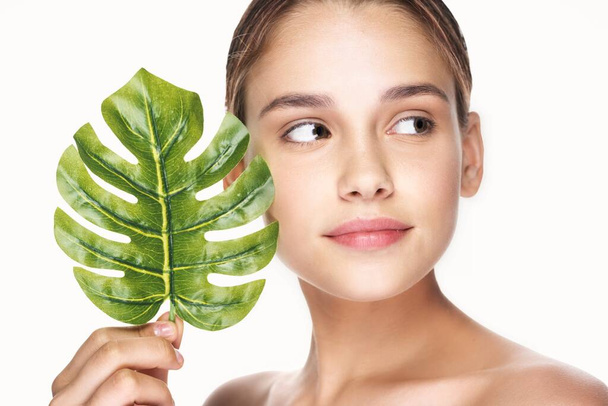 Young beautiful wman  posing with leaf in studio - Photo, Image