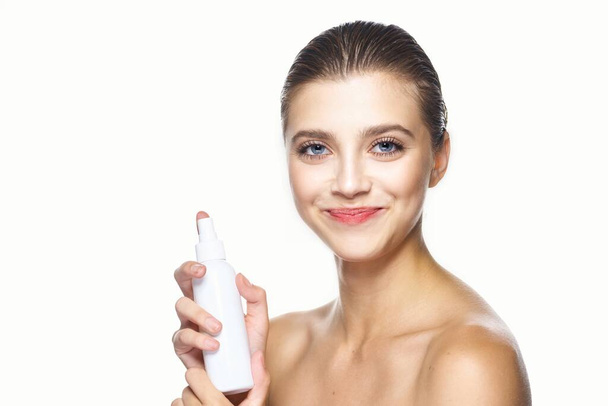 Студійний знімок. Портрет молодої красивої жінки з косметичним продуктом ізольовано на білому тлі
 - Фото, зображення