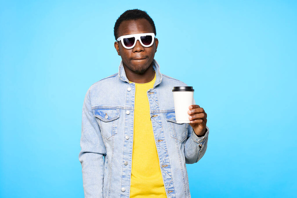 Young man  with coffee cup   isolated on blue background - Photo, Image