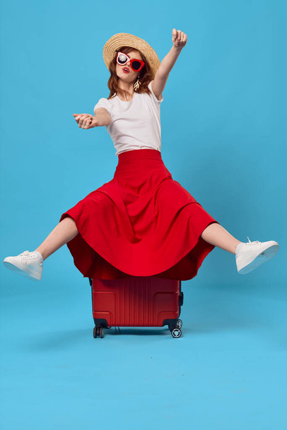 Giovane donna con valigia rossa in studio - Foto, immagini