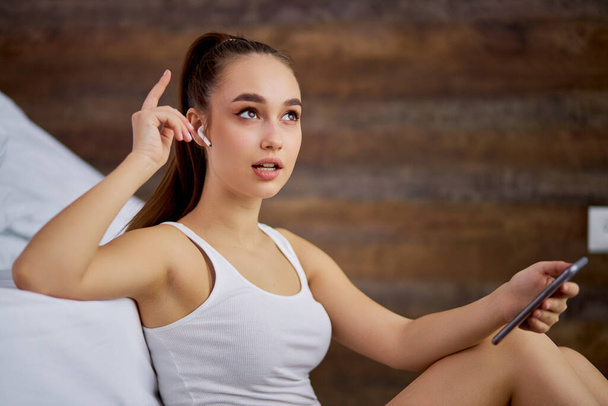 charming woman sings a melody from headphones at home - Foto, Bild