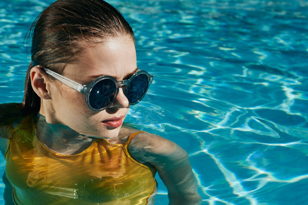 Young beautiful woman relaxing in the pool   - Foto, Imagen