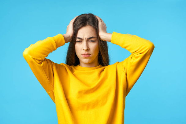 Young woman  with headache   in studio isolated on blue background  - Foto, imagen