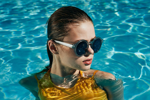 Young beautiful woman relaxing in the pool   - Photo, Image