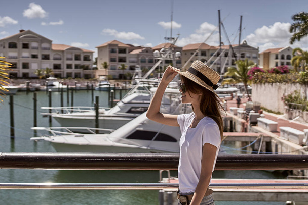        jonge mooie vrouw in stro hoed staan op de pier                      - Foto, afbeelding