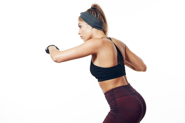 Studio shot. Young fit woman boxer exercising, isolated background - Foto, afbeelding