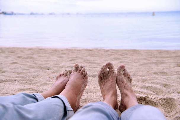 Zwei Paar nackte Füße am schönen Strand einer tropischen Insel. Wunderbarer Urlaub und Erholung auf der paradiesischen Insel. - Foto, Bild
