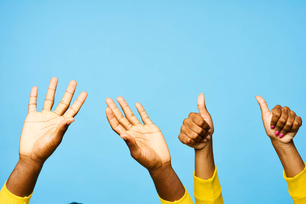young african man and woman with hands up  on blue background  - Photo, Image
