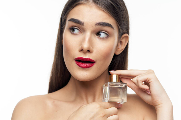Ritratto di giovane bella donna con bottiglia di profumo isolato su sfondo bianco - Foto, immagini