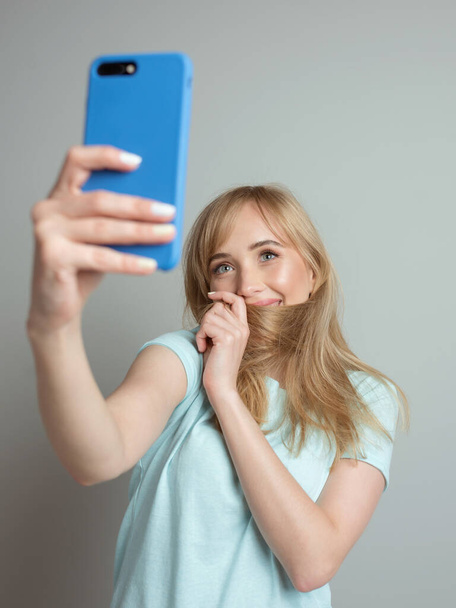stylish beautiful blonde woman blogger making selfie with her smartphone. Trend, technology, beauty, fashion concept - Fotografie, Obrázek