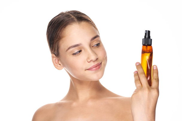 Young beautiful woman holding hairspray. Studio shot - Foto, Bild