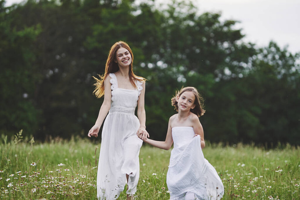 Junge Mutter und ihre Tochter amüsieren sich auf Kamillenfeld - Foto, Bild