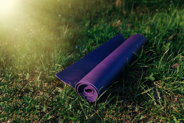 Rolled Mat for yoga or fitness on grass - Photo, Image