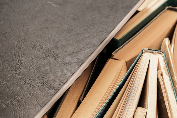 Black notebook lying on the side of books - 写真・画像