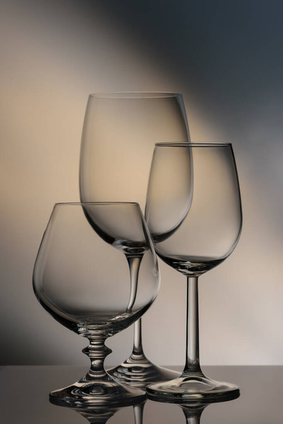 Still life. Glass to clear. Glasses of different heights on a colored background. - Photo, Image
