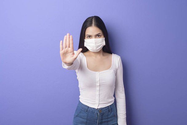 portrait of young woman is wearing face mask on purple background  - Valokuva, kuva