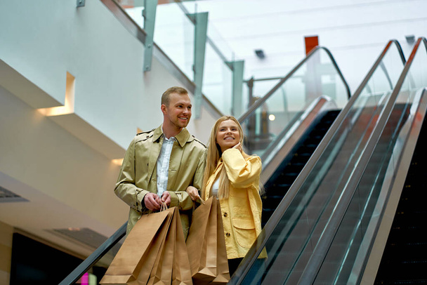 beautiful married couple on escalator in shopping mall - Photo, Image