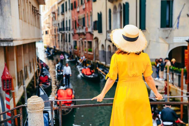 γυναίκα σε κίτρινο φόρεμα ήλιο στη γέφυρα με θέα στο venice κανάλι ρομαντική πόλη. ταξιδιωτική έννοια - Φωτογραφία, εικόνα