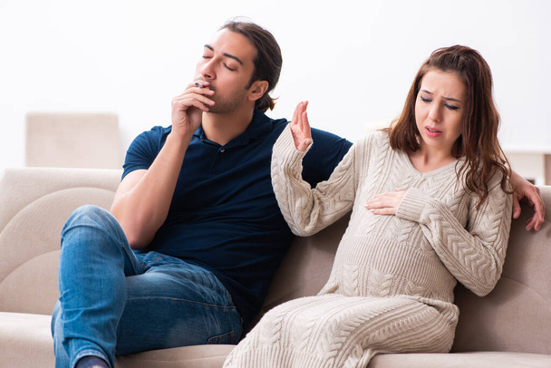 Man and pregnant woman in antismoking concept - 写真・画像