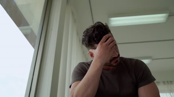 salud mental, los hombres sentados estresados por la ventana, en una condición epidémica covid -19, lo que le hace perder su trabajo
 - Metraje, vídeo
