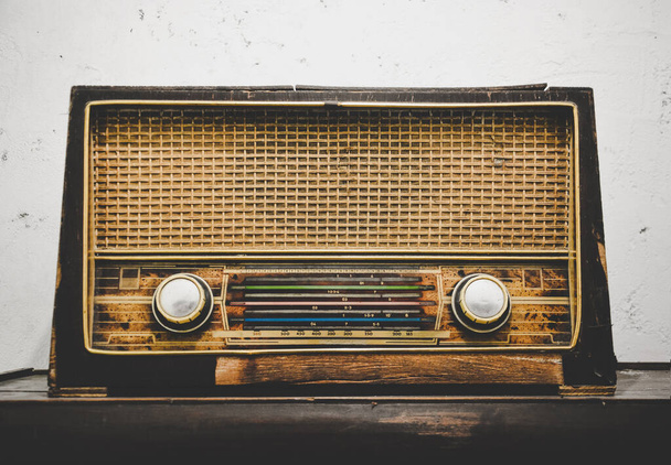 viejo receptor de radio de madera retro en mesa de madera con fondo de pared de yeso de cemento grunge blanco, efecto vintage - Foto, Imagen