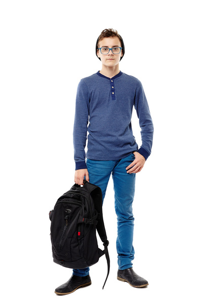 Trendy teenager wearing glasses holding his backpack in hand - Fotó, kép