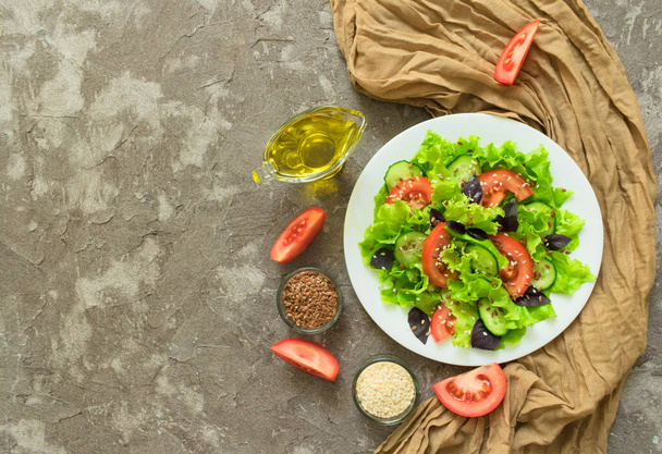 Uma salada saudável de legumes, ervas e sementes em um fundo de textura cinza. Vista superior. Espaço de cópia
. - Foto, Imagem