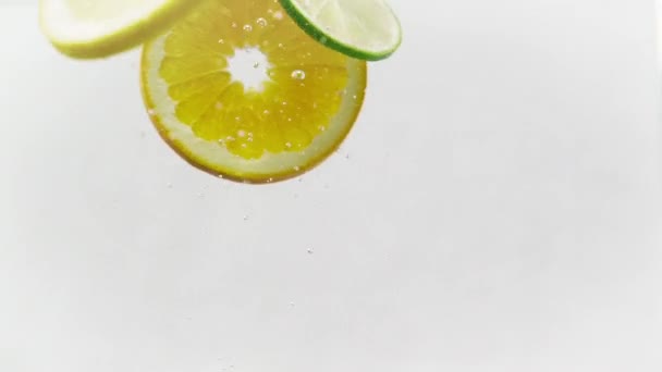 Lemon, Lime, and Orange Slices dropped into a fish tank, 1080p 120fps. - Video, Çekim