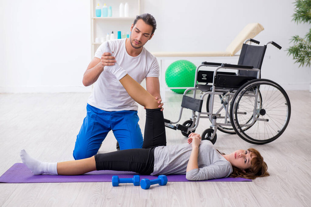 Poot gewonde vrouw doet sport oefeningen met personal coach - Foto, afbeelding