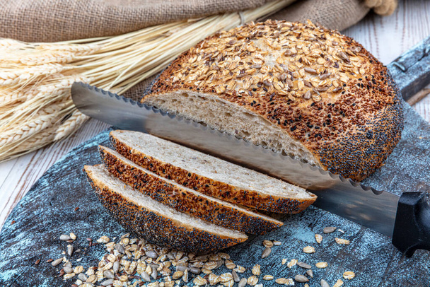 Свіжий домашній хліб. Французький хліб. Шматок хліба і різання ножа на сільському столі..  - Фото, зображення