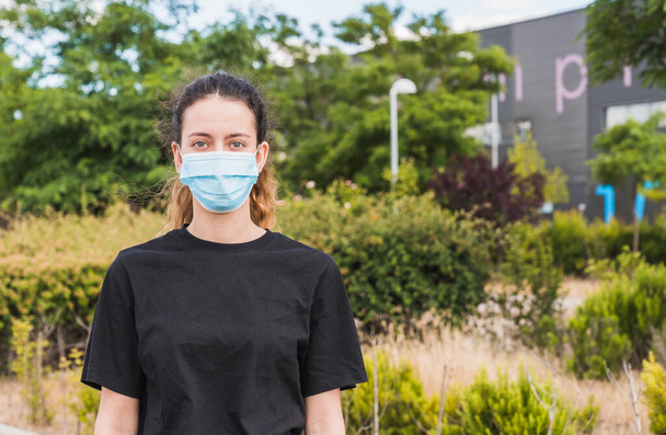 Teenager with a mask. Young girl walking down the street with a protective mask. New normal. Human life in Social distance. Safety and pandemic concept. Coronavirus. Social distance. - Photo, Image