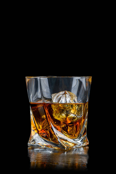 Szklanka whisky lub innego alkoholu z lodem kostki na czarnym tle - Zdjęcie, obraz